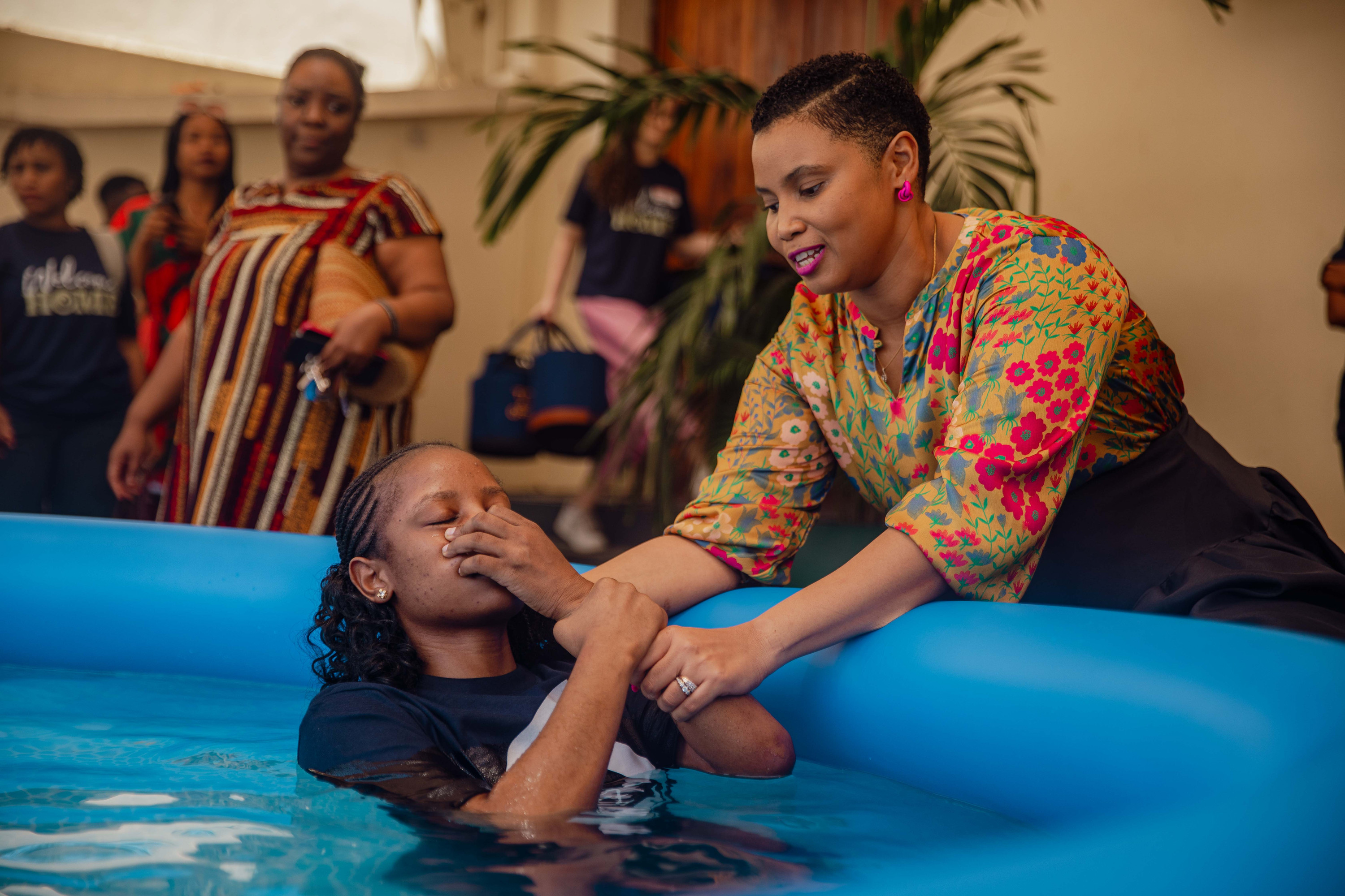 A woman comes up from the water at her baptism