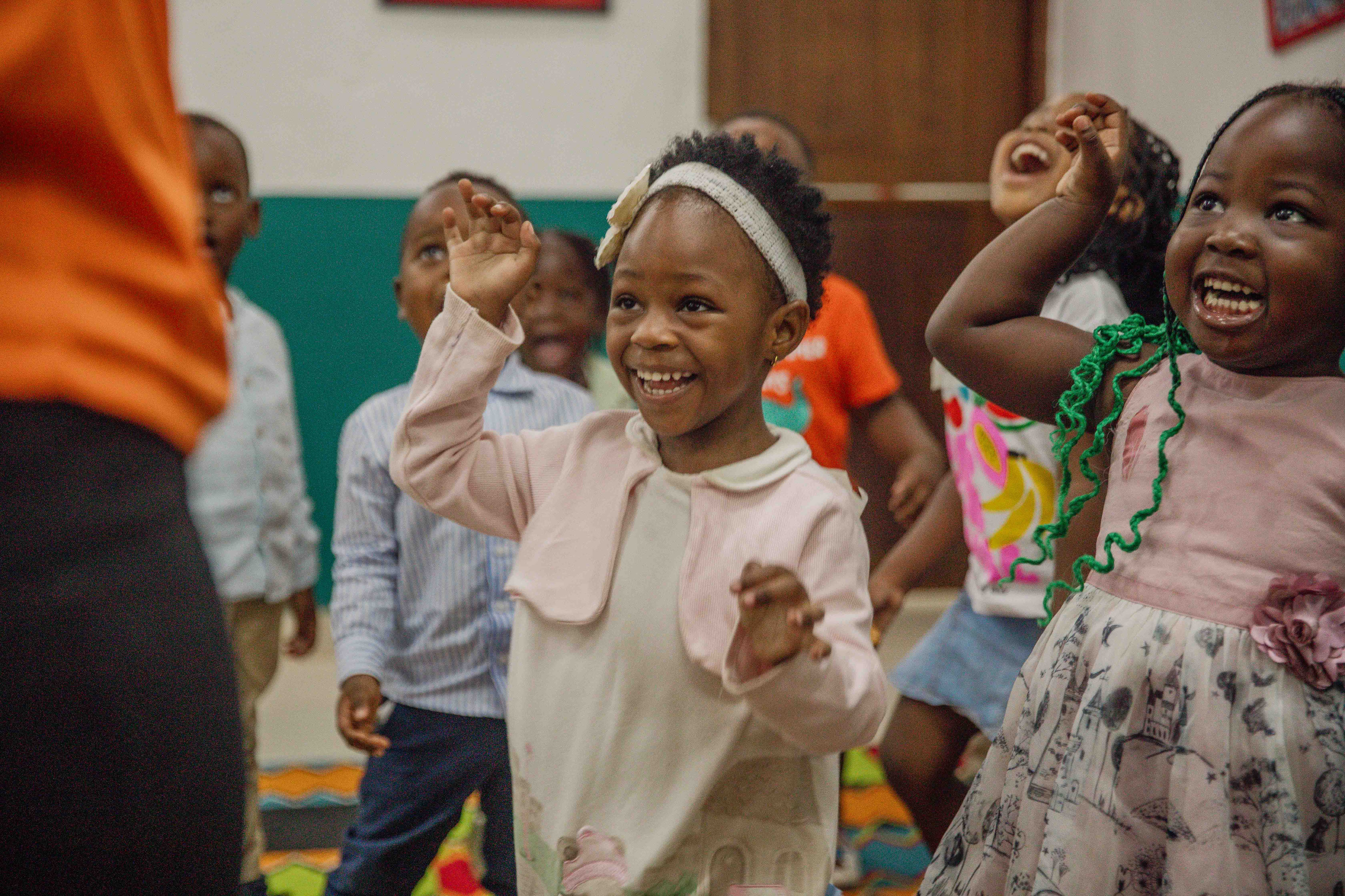 Small children dance and laugh in the kids' room