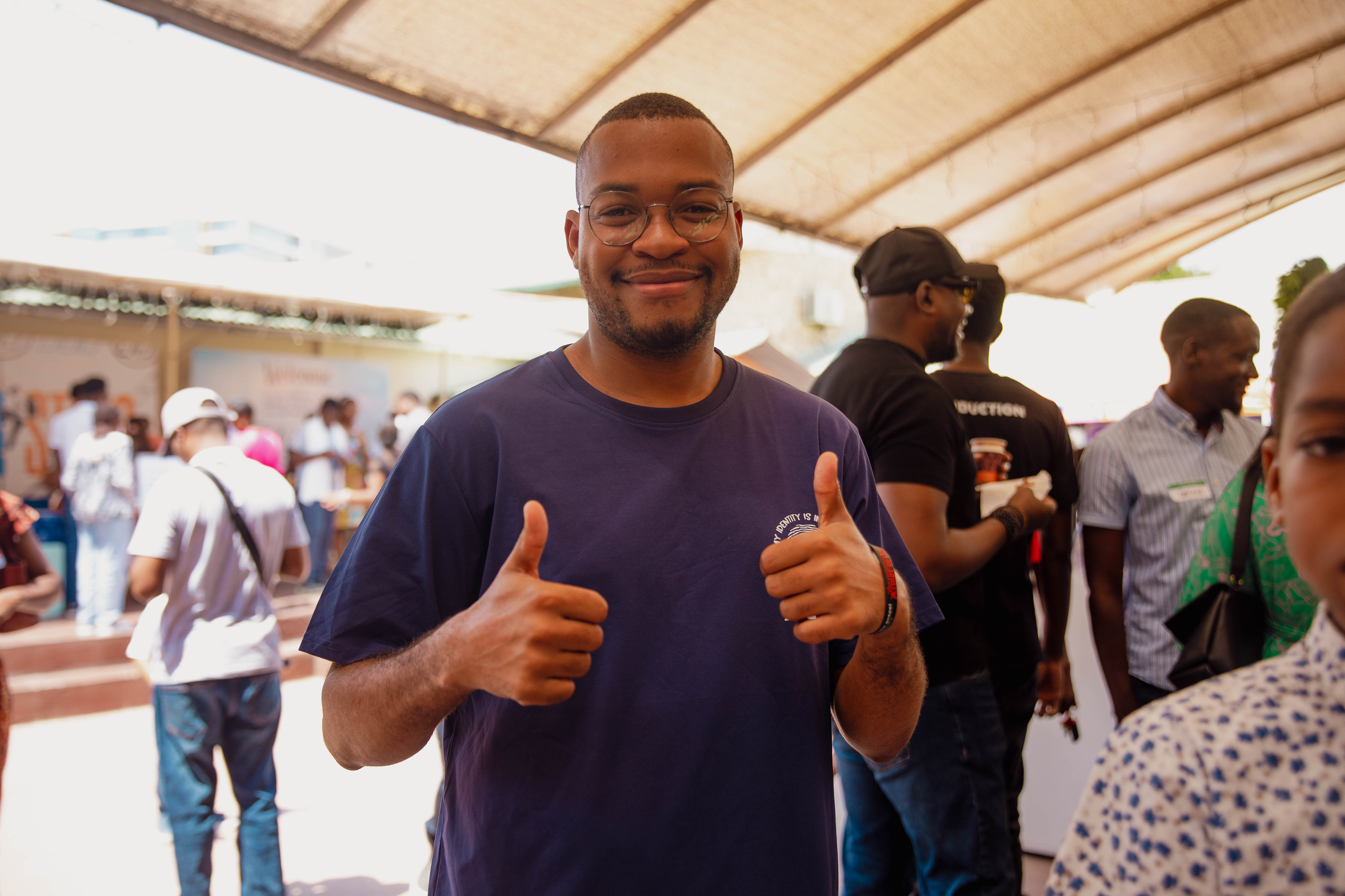 A man gives two thumbs up at the entrance on a Sunday