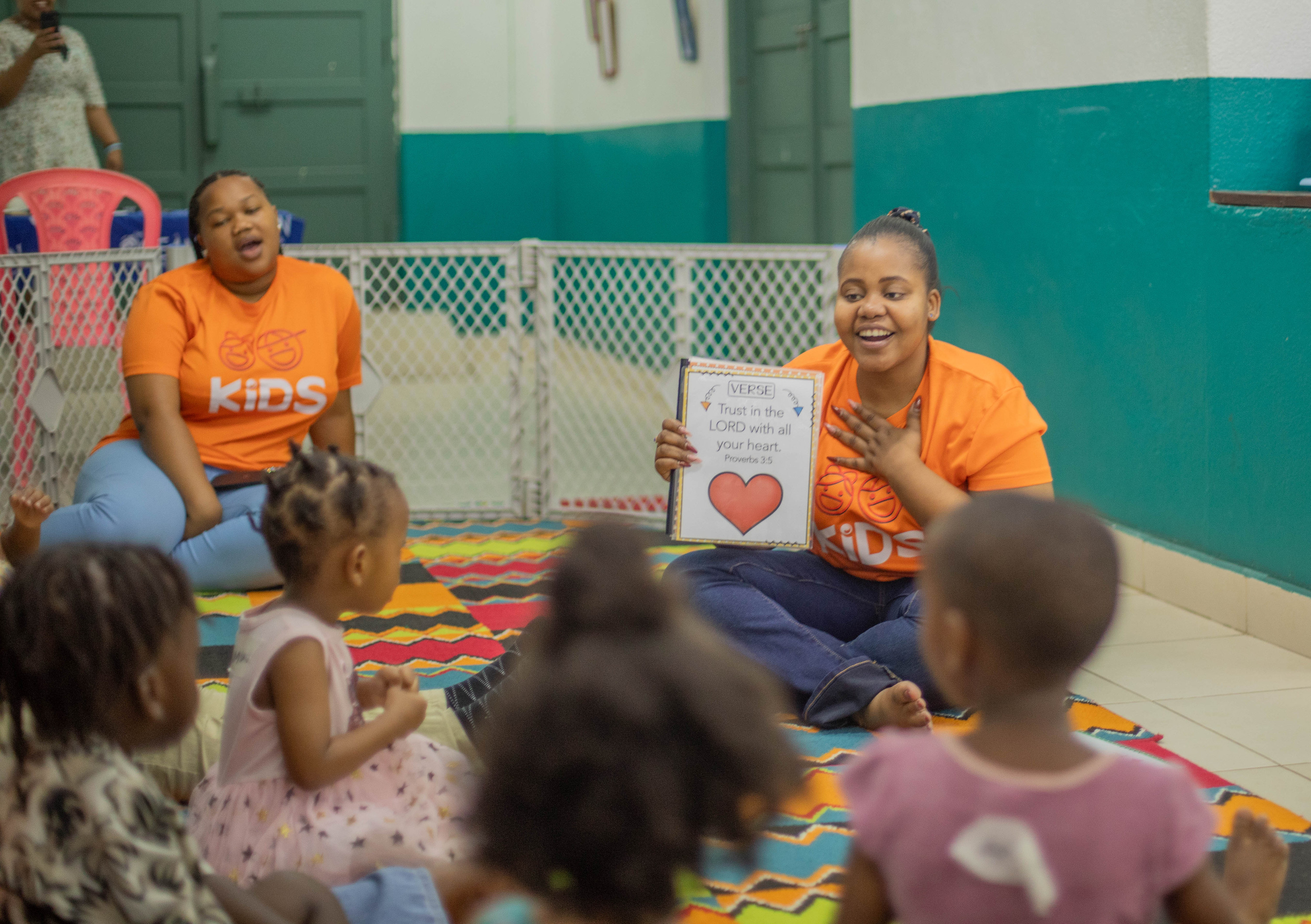 A volunteer holds up a card for babies and toddlers