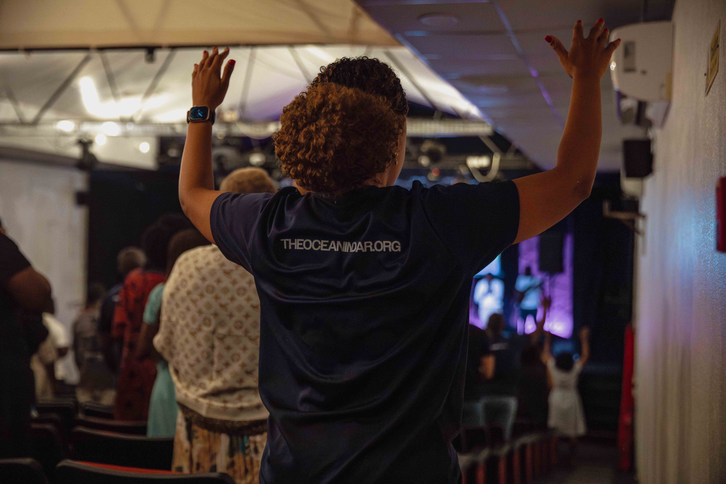 A woman worships with her arms raised